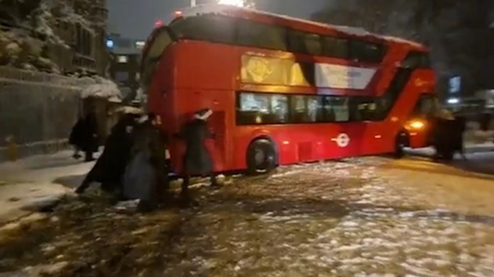Londoners band together to move bus stuck during heavy snowfall