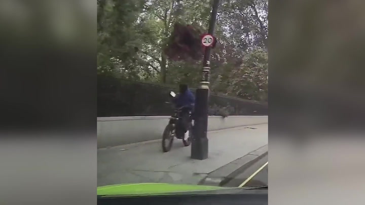 Brazen thief on electric bike snatches a woman's phone outside London's Ritz Hotel