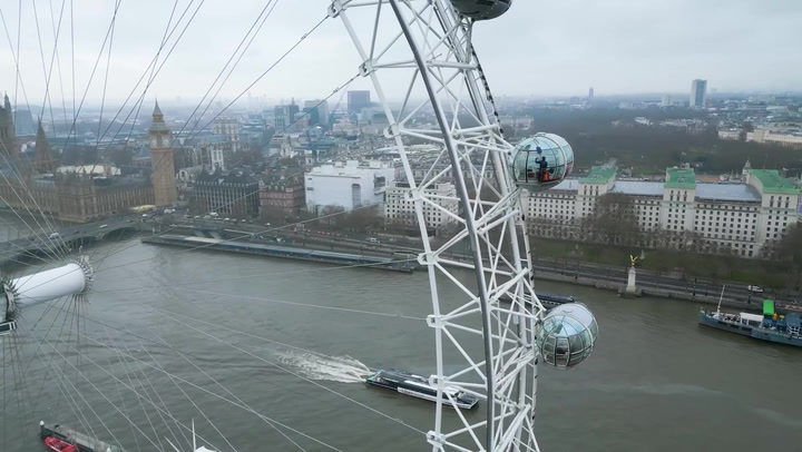 Window cleaners dangle 443ft in the air to polish London Eye