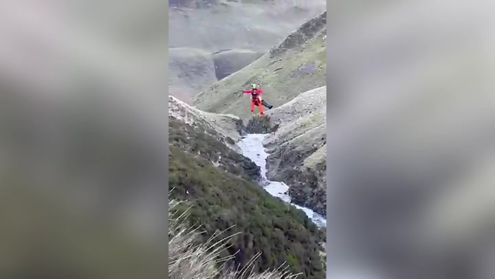 Moment hiker who fell 60ft down a waterfall is airlifted to safety