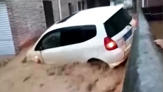 Cars float down streets as deadly floods hit China