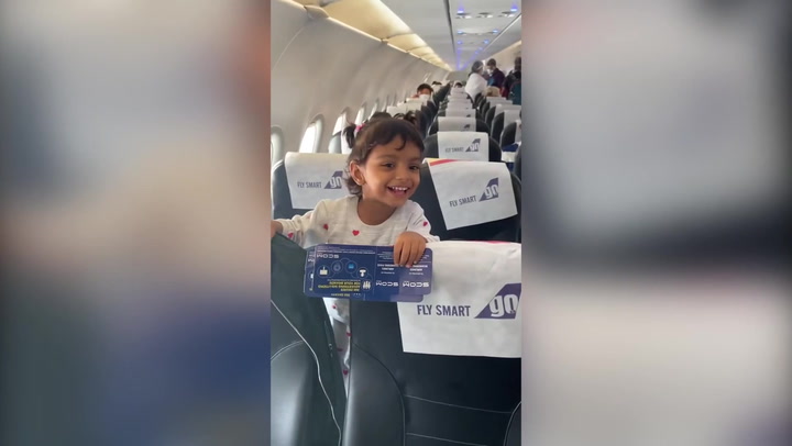 Young girl giggles with excitement when she realises her dad is pilot on flight