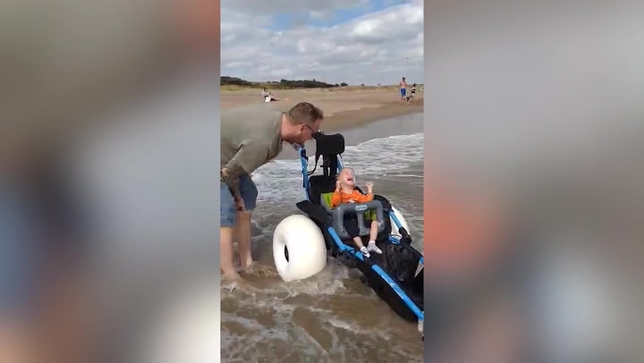 Toddler with cerebral palsy enjoys the sea for the first time thanks to new wheelchair