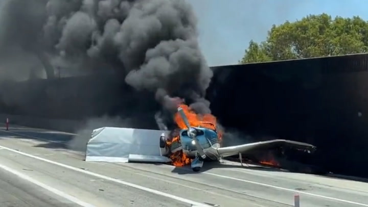 Fiery wreckage of plane burns on busy Californian freeway after crash landing