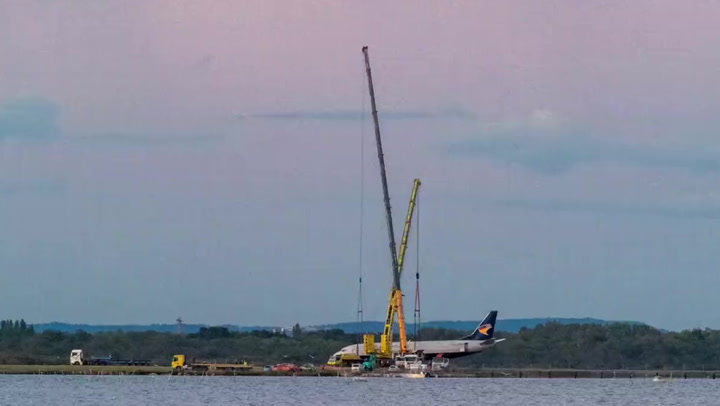 Boeing plane that crashed in French lake lifted out by gigantic crane