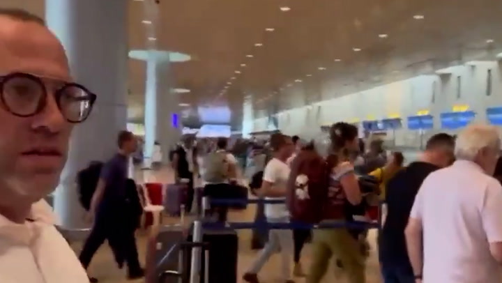 Travellers ditch luggage and race to board planes out of Israel as rockets fired nearby
