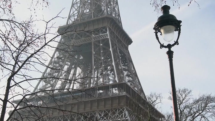 240118 Tourists Revel As Snow Blankets Eiffel Tower And Other Paris Monuments