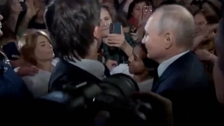 Putin kisses young girl on the head as he mingles with people during Dagestan visit