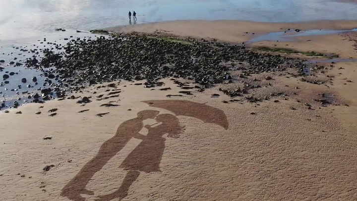Beach artist creates stunning artwork with thousands of rocks at low tide