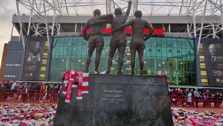 Man United fans cover Bobby Charlton statue with flowers and scarves ahead of Champions League match
