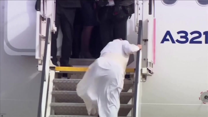 For heaven's sake: Pope Francis stumbles as he boards plane in strong winds