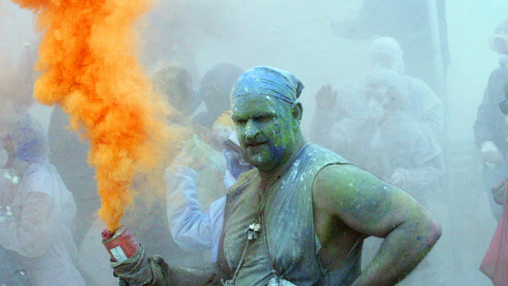 Greek revellers throw coloured flour at each other in 200-year-old carnival tradition
