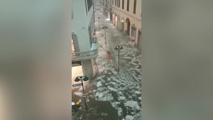 Icy water flows through streets of Italian town after freak hail storm.mp4