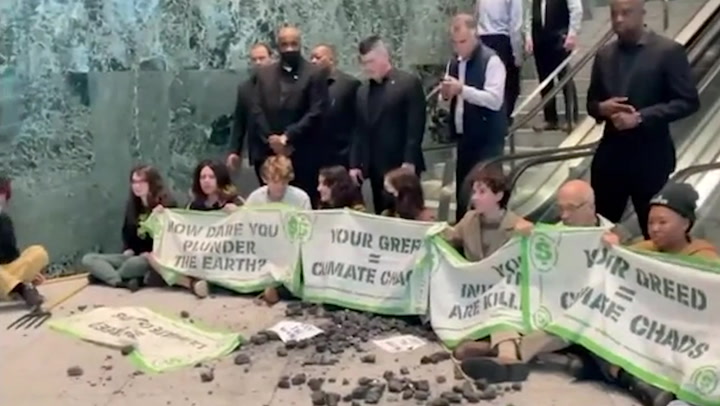 Climate protesters occupy BlackRock HQ throwing black rocks onto floor