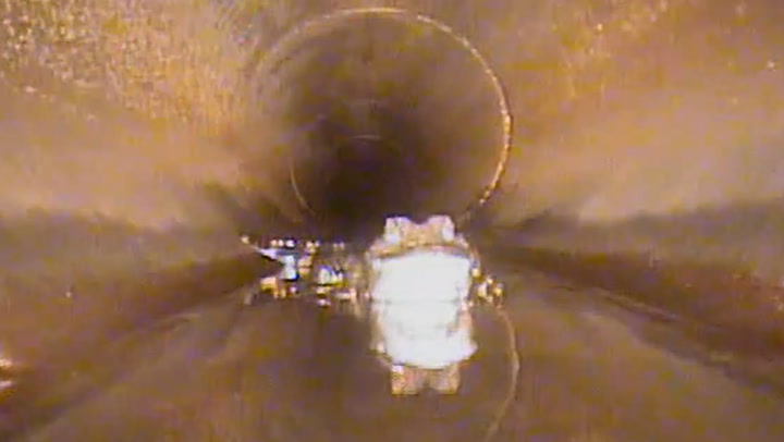 Alligator comes face-to-face with robot while hiding in storm drain