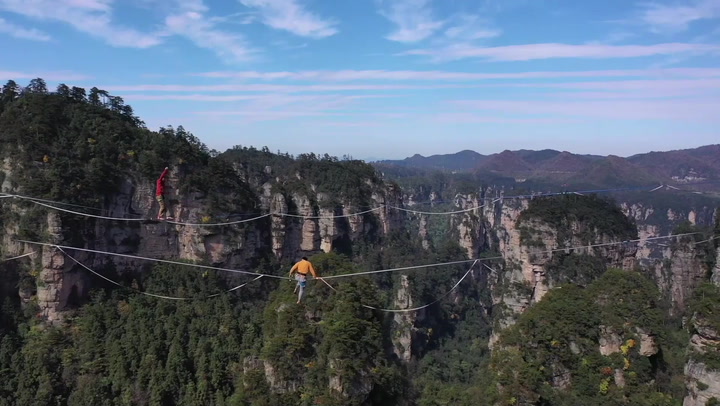 Thrill-seekers perform 1,000m-high slackline walk in China