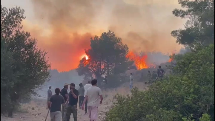 Rhodes residents join wildfire fight with shovels, tree branches, and towels