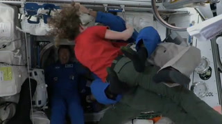 Astronauts hug as new crew arrives at International Space Station