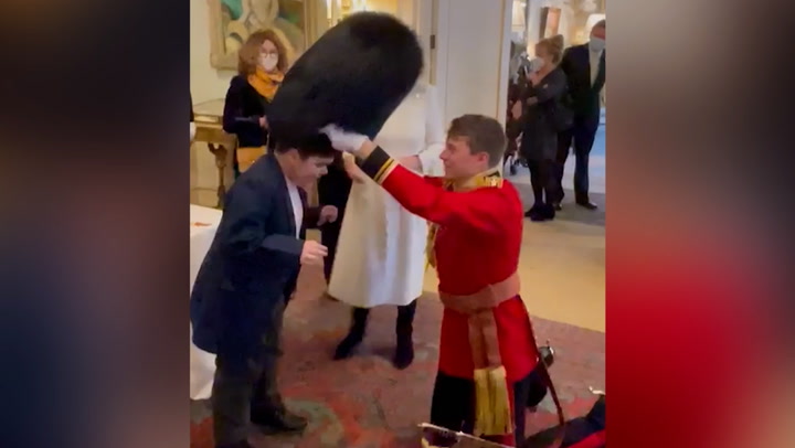 Adorable moment boy tries on The Queen's Guard's bearskin hat