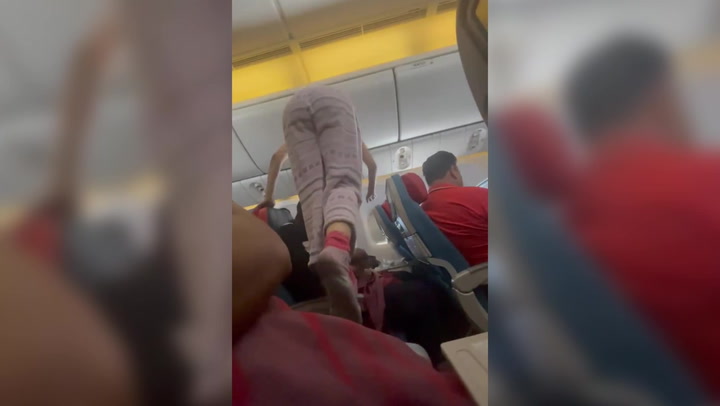 Woman climbs over plane passengers to get to her seat