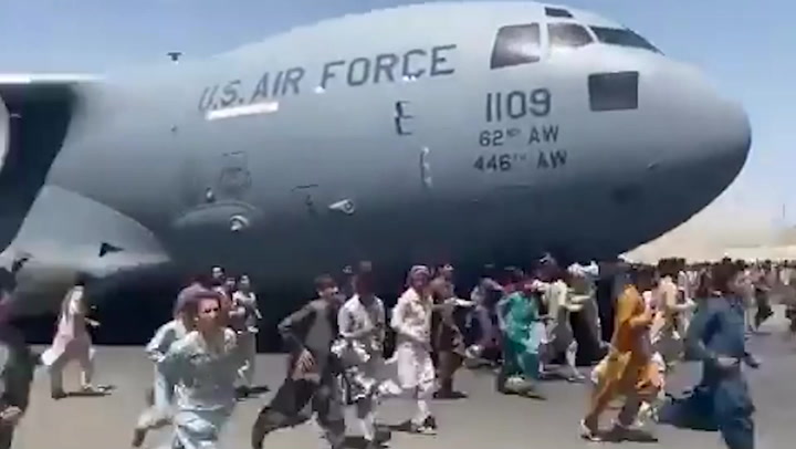 Desperate Afghans climb onto plane during takeoff as crowds try to flee Taliban