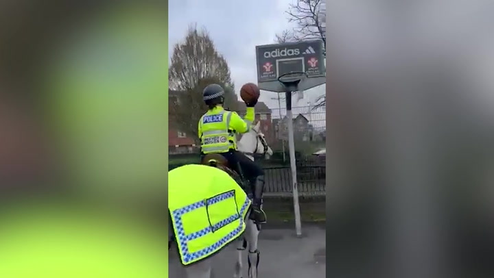 One-trick pony: Police officer plays basketball while riding horse