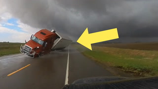 The heart-stopping moment a semi-truck tips and slams into passing car