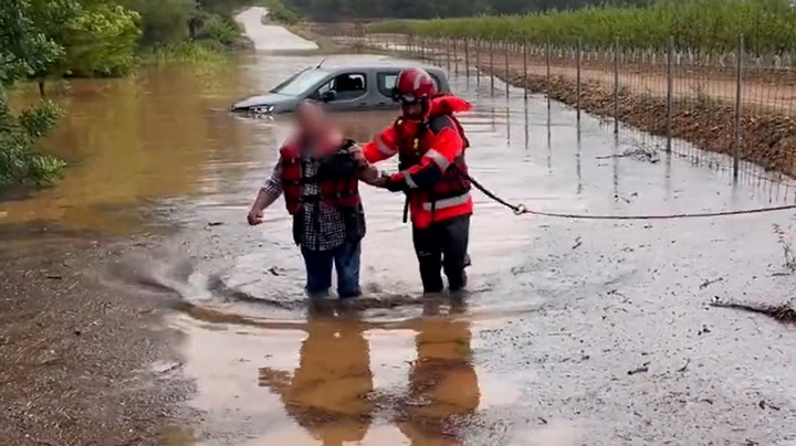 Firemen rescue people trapped in cars by Storm Dana floods in Spain