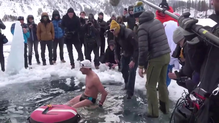 Watch this diver plunge into icy Swiss lake