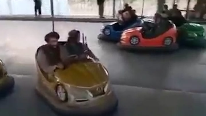 Armed Taliban militants appear to ride bumper cars and merry-go-round