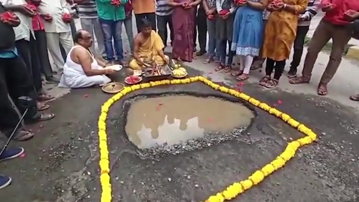 Priests worship enormous potholes praying they don't injure people