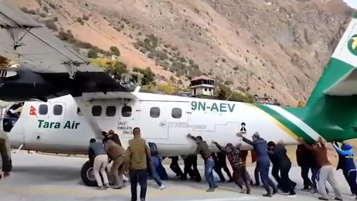 Passengers push plane off runway after tyre bursts