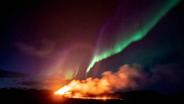Northern Lights shine over Iceland's erupting volcano in stunning footage