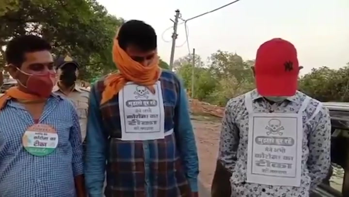 Indian police stick skull banners to chests of unvaccinated people