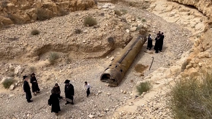 Israeli hikers inspects debris from downed Iranian missile