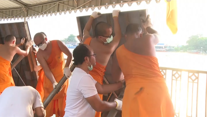 Monks help to build flood defences in Thailand