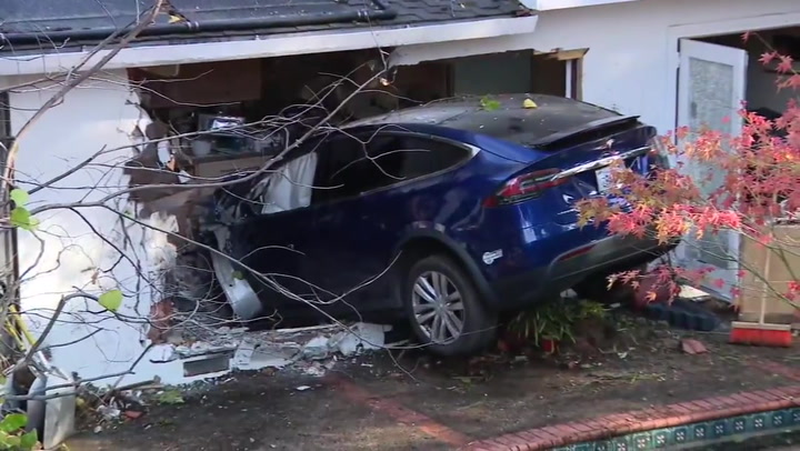 Tesla crashes into family's kitchen after soaring over pool