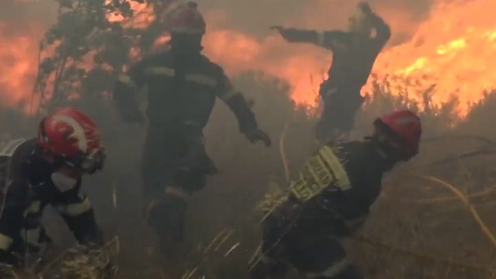 Firefighters run from aggressively fast-moving wildfire in Eastern Spain