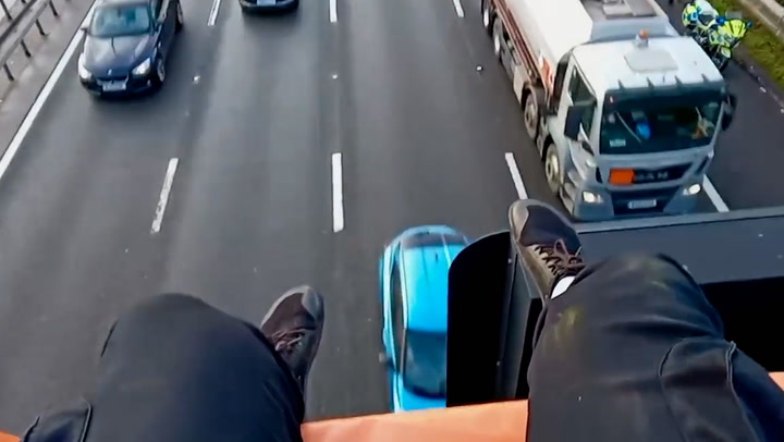 Just Stop Oil activist dangles legs over M25 gantry on second day of protests