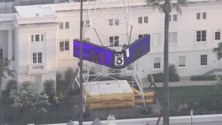 Hombre sube a una torre con un cartel de ‘Free Billie Eilish’