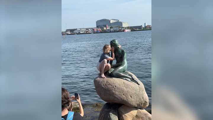 Tourist booed as she climbs Copenhagen's Little Mermaid statue despite warnings