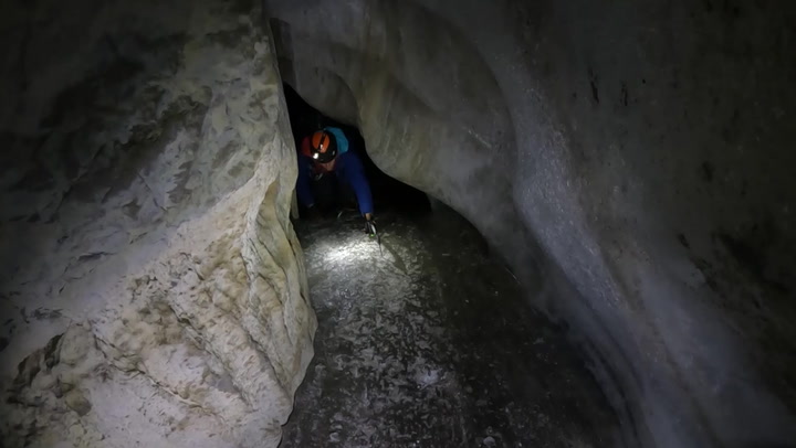 Daredevil group abseil into beautiful ice cave in Swiss Alps