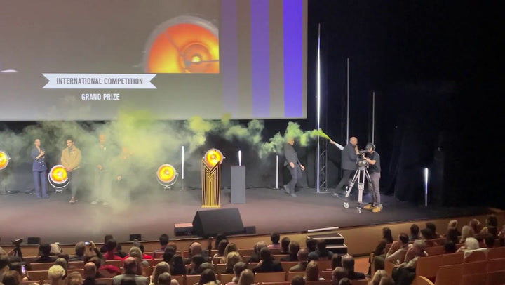 Activist lights flare on stage during TV festival in France