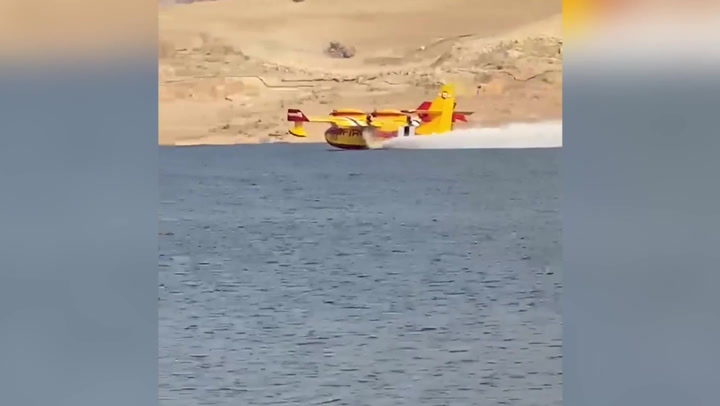 US Wildfires: Firefighting plane collects water as windy fire burns nearly 90,000 acres
