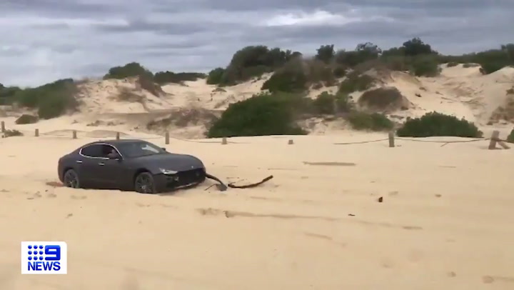 Intentan sacar un auto de lujo atascado en la playa pero algo sale mal - Fuente: 9News