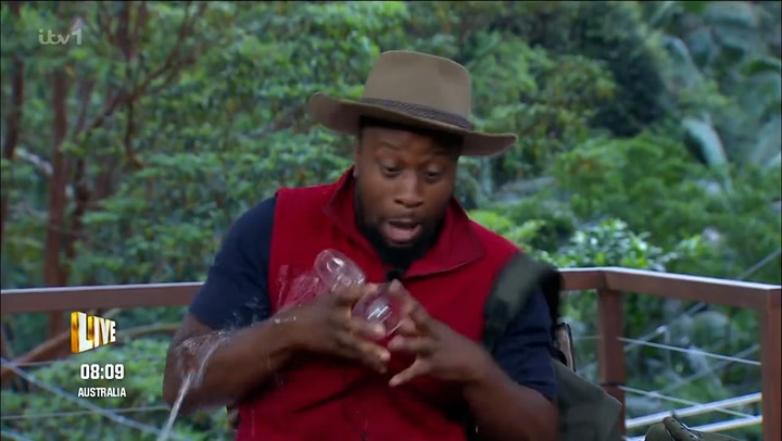 Babatunde Aleshe excitedly spills champagne over himself as he leaves I'm a Celeb jungle