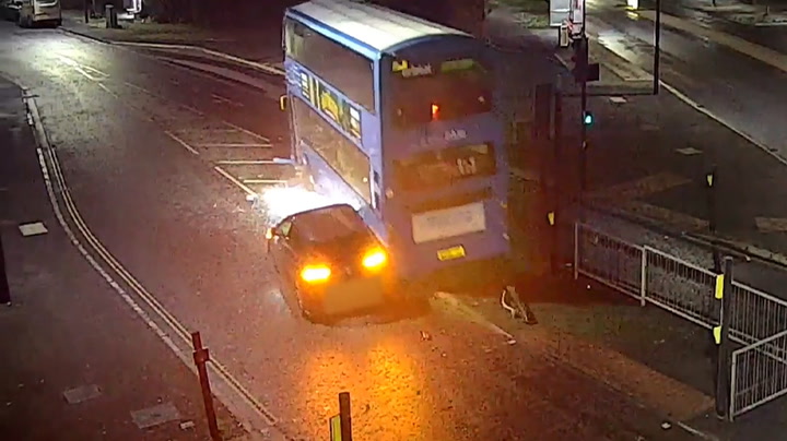 Moment speeding car collides with bus and causes it to crash into house