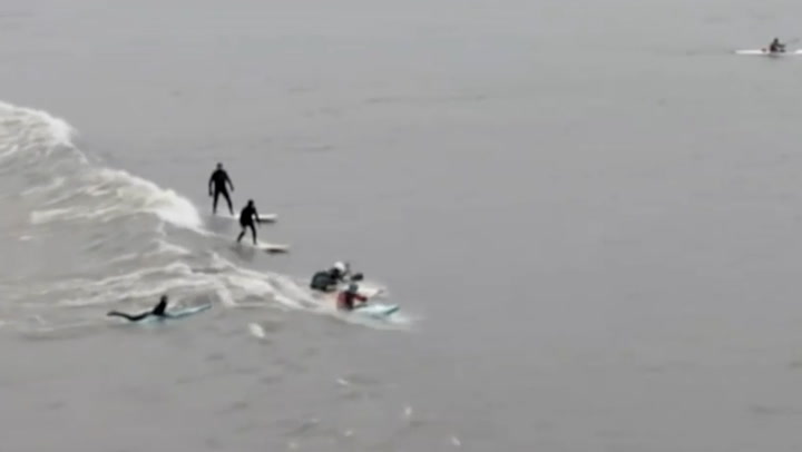 Surfers ride Severn Bore as it sweeps up estuary