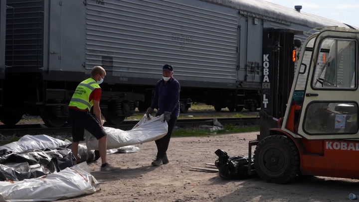 Ukrainian soldiers load bodies of deceased Russian troops into refrigerated train