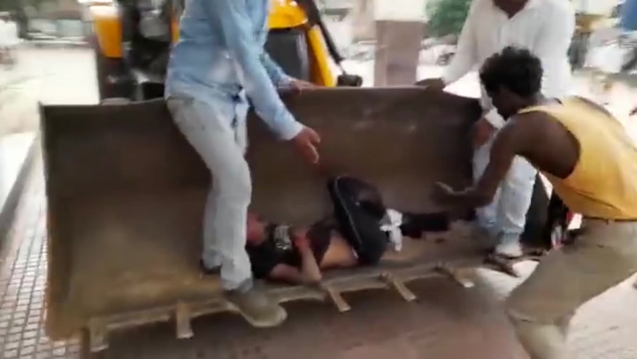 Injured man carried to hospital by digger in India